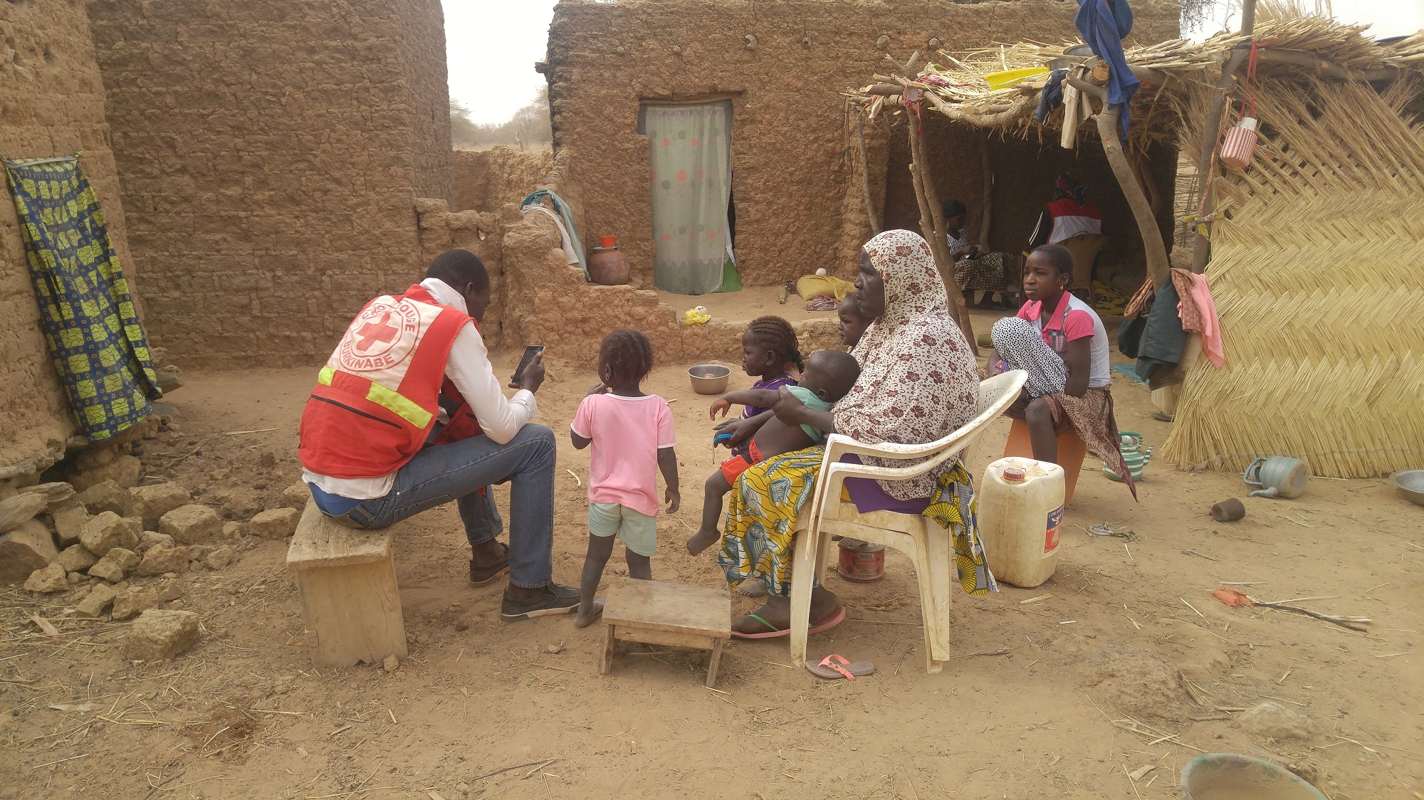 L’enregistrement sur smartphone des ménages déplacés par un volontaire de la Croix-Rouge burkinabé.